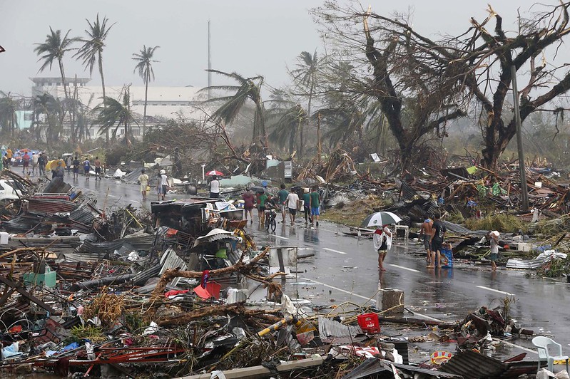 Residents walk on a road littered with debris after Super Typhoon Haiyan battered Tacloban city in central Philippines November 10, 2013