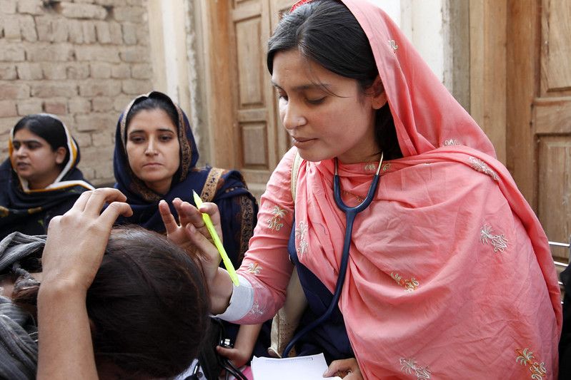 A doctor examines a woman patient at a mobile health clinic in Pakistan