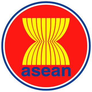 ASEAN logo, a red circle with a white and blue border with a yellow hourglass in the middle.