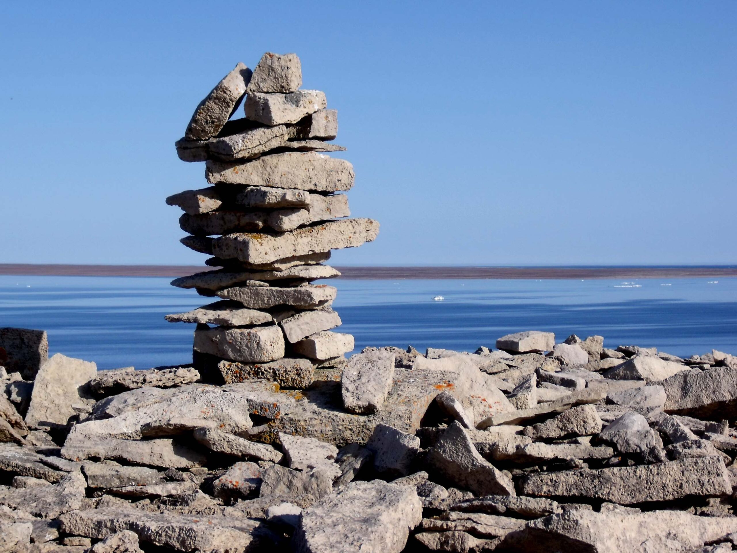 A inukshuk uphill from Igloolik, Nunavut, Canada. About 5 feet tall and made of flaggy dolomite.