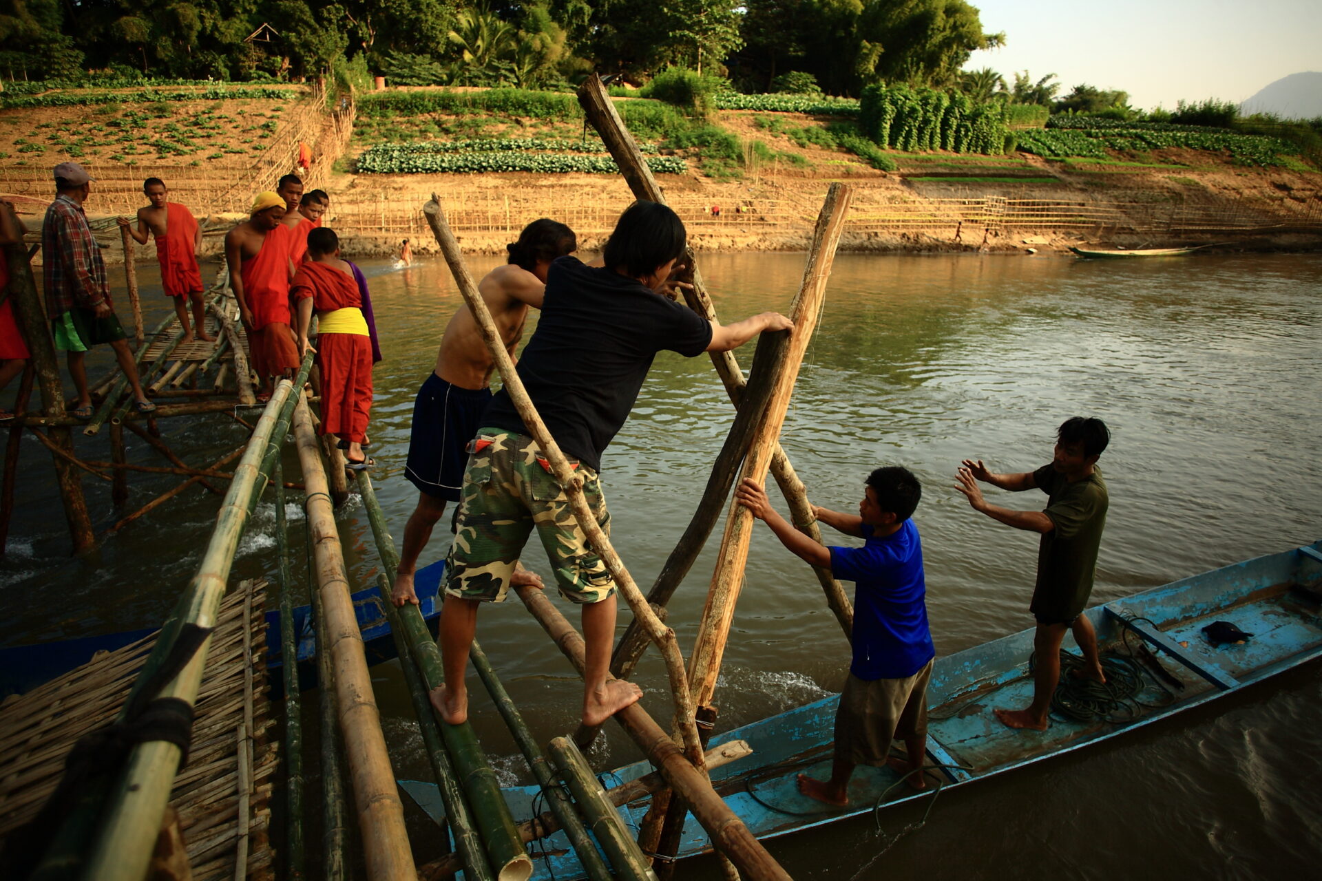 Residents repair a damaged bridge in Lao PDR