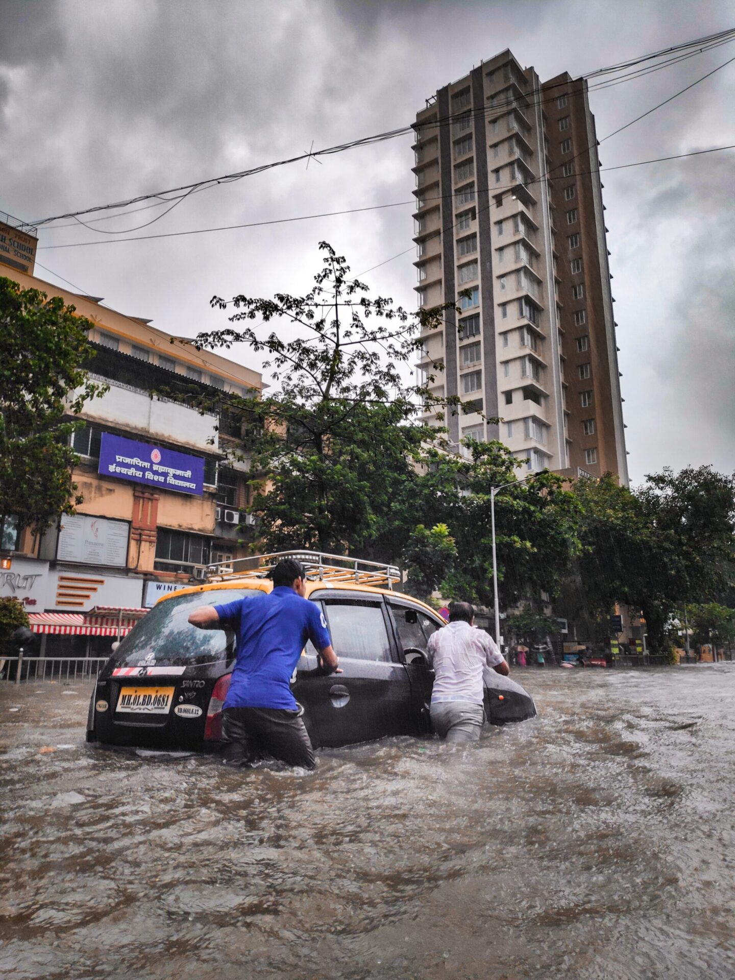 Men beside a car during floods