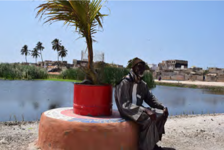 Mamadou Ndiaye, délégué de quartier of Bene Baraque sitting on a design bench. Benches made from recycled materials are arranged around the basins to improve the living environment of the neighbouring districts. Credit: Consortium pour la Recherche Economique et Sociale (CRES).