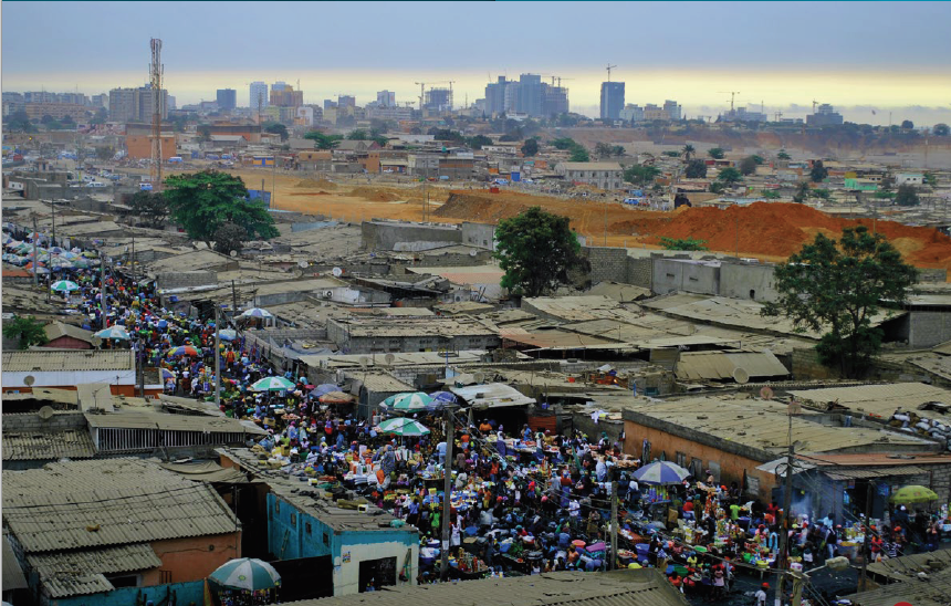 faraway view of the city of luanda, with an informal settlement in the foreground and tall buildings in the background