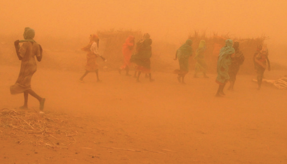 An image of human silhouettes in the middle of a dust storm which obscures most of the image