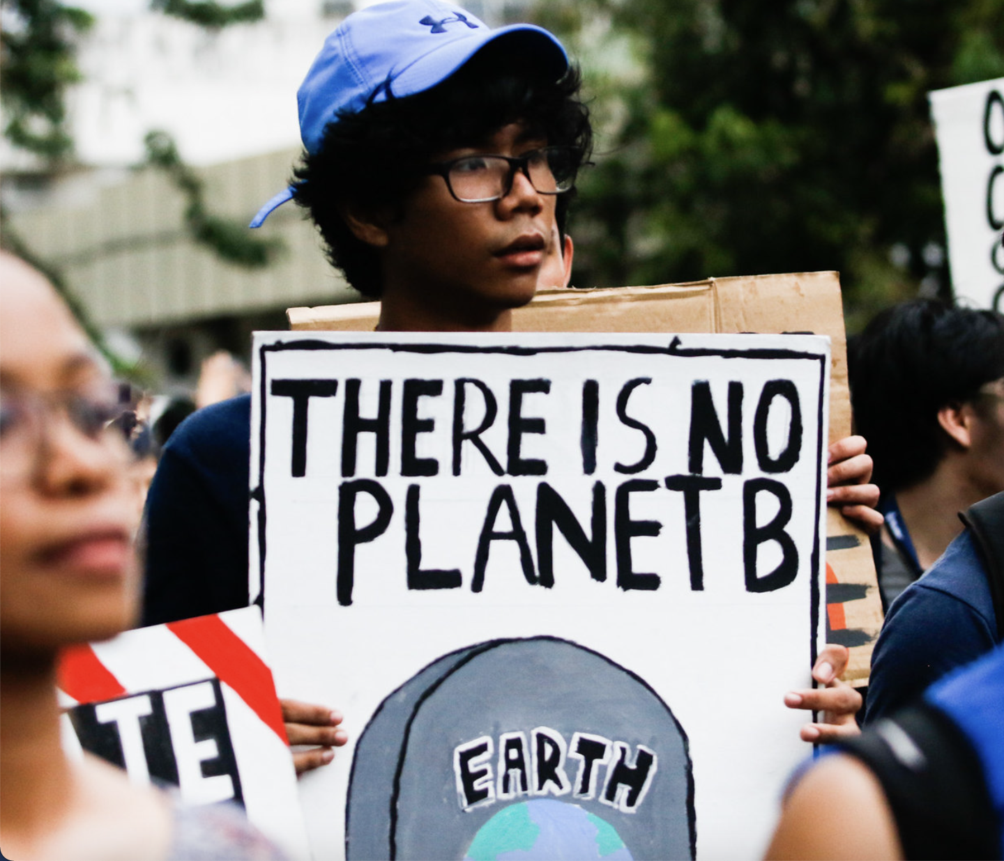 A young man carrying a sign that says "There is no Planet B"