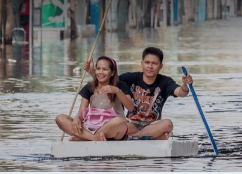 Couple floating down flooded main road