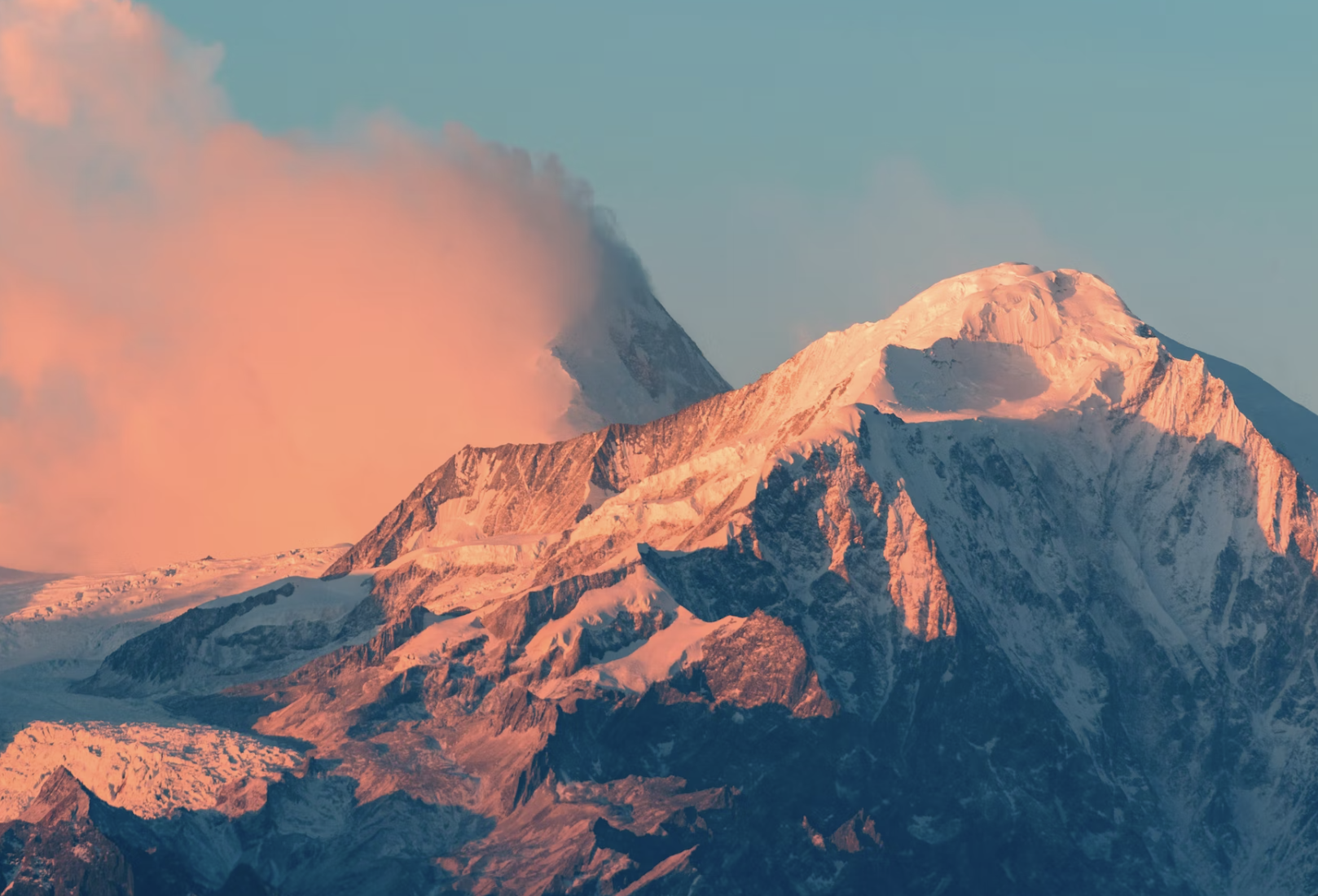 Mountain with a snowy peak and a pink cloud sky